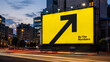 © Rodrigo - Large yellow billboard with a black upward arrow and 'By The Numbers' text overlooking a city street at night
