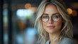 © Afan - Blonde woman with glasses indoors, blurred background