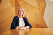 © baranq - Confident businesswoman sitting at conference table in modern office