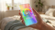 © Hypnotics 14 - Person holding smartphone with digital wellness score tracking app in a bright bedroom