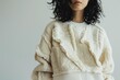 © nsit0108 - Close up of a fashion model showcasing a trendy winter white sweater with unique textured details, highlighting the garment's design and cozy appeal