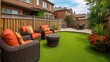 © Plaifah - Cozy backyard retreat with modern furniture, vibrant green artificial lawn, colorful flowers, and comfortable seating amid a serene residential neighborhood