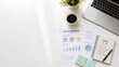 © AMH FX STOCK - Business planning workspace with mid year review documents and colorful graphs on white desk
