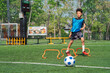© chokniti - World cup concept with soccer ball or football player, youth soccer training on outdoor field with boy practicing agility near ball