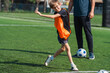 © chokniti - World cup concept with soccer ball or football player, young boy playing soccer on green field with coach in background