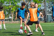 © chokniti - World cup concept with soccer ball or football player, youth soccer players practice on outdoor field with ball and orange and blue vest, active team sport training in sunny park