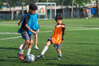 © chokniti - World cup concept with soccer ball or football player, soccer practice on outdoor field with two boys in training bibs and ball, active youth sport teamwork