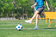 © chokniti - World cup concept with soccer ball or football player, soccer player kicking ball on green field, outdoor practice with training equipment and fence