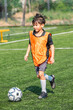 © chokniti - World cup concept with soccer ball or football player, young boy soccer player orange vest field ball running sport child outdoor juvenile athlete grass training practice game competition action