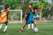 © chokniti - World cup concept with soccer ball or football player, youth soccer practice on outdoor field with children in training bibs and ball showing teamwork and focus