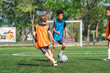 © chokniti - World cup concept with soccer ball or football player, youth soccer player on field with ball and goal in sunny park