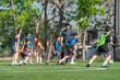 © chokniti - World cup concept with soccer ball or football player, youth soccer practice on outdoor field with coach and children training together
