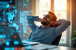 © miss irine - Man relaxes in office chair with hands behind head. Futuristic digital world map hologram displays on screen. Laptop shows data charts on table.