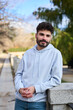 © Oscar - Young man smiling wearing hoodie in urban park