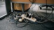 © God's blessing - Messy tangle of electrical cables and power strips under office desk.