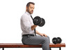 © Ljupco Smokovski - Businessman in a shirt and tie lifting a dumbbell on a wooden bench