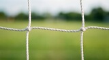 Close up of a soccer net against a blurred green field