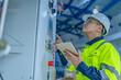 © reewungjunerr - Asian electric engineer holding clipboard for checking and monitoring the electrical system in the control room,Technician thailand people working