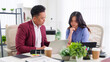 © Pichsakul - Asian business professionals team meeting coworkers discuss project strategy review documents collaborate on tablet laptop modern office workspace concept