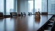 © Silhouette_Studio - Small house model on conference table symbolizing real estate economics and investment decisions