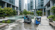 © Margarita Ratatosk - Floor scrubber machine and janitor cart standing on wet courtyard by modern office building. Professional city cleaning service equipment for daily maintenance of urban area exterior.