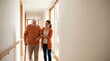 © tebu - Young Female Caregiver Walking with Senior Man Using Cane in Bright Hallway of Care Home or Rehabilitation Center