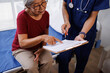 © David - Senior asian woman consulting with nurse, discussing medical checklist and treatment plan, understanding healthcare information, making informed decisions on health insurance forms at clinic