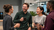 © Anas - Diverse corporate colleagues laughing together and sharing a happy moment over coffee in a bright office breakroom, reflecting natural candid emotion, teamwork, and a positive workplace culture.