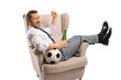 © Ljupco Smokovski - Man in formal clothing sitting in an armchair with a football and beer celebrating
