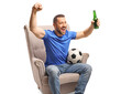 © Ljupco Smokovski - Football fan sitting in an armchair with a beer celebrating