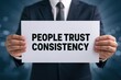 © Prazis Images - Man in Suit Holding a Sign: People Trust Consistency