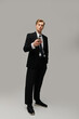 © LIGHTFIELD STUDIOS - Stylish young man in sharp suit looking at his phone against a neutral backdrop