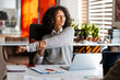 © Maria Vitkovska - Young woman stretching arm enjoying a wellness break in office