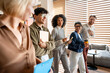 © Maria Vitkovska - Diverse business professionals walking, smiling in modern office