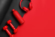 © New Africa - Sports equipment, water bottle and headphones on red background, flat lay. Space for text