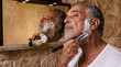 © Ed - portrait of an elderly Latino man shaving in front of a mirror with a straight razor, concept for daily hygiene and men's health care, copy space for text