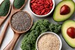 © whitestorm - Assortment of healthy superfoods including avocado, kale, goji berries, chia seeds, quinoa, and spirulina powder.