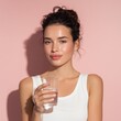 © Flower images - グラスの水を持つ女性のポートレート。美容や健康、ライフスタイルのイメージ素材