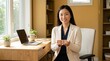 © Clark Still - A professional woman sitting by a desk in an office environment holding a model of a house