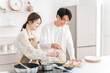 © buritora - A young Asian couple cooking in their home kitchen.