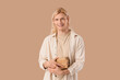 © Pixel-Shot - Young blonde man with books on beige background