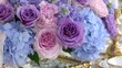 © alice - Abundant arrangement of purple and pink roses mixed with light blue blossoms creates a centerpiece display.