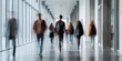 © Generative AI - Blurry motion of diverse students walking down a modern university hallway with large windows