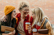 © La Famiglia - Diverse students laughing together on campus with coffee