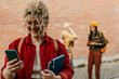© La Famiglia - Student smiling and using smartphone on campus