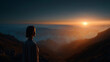 © Wasin Arsasoi - Serene contemplation: A silhouette of a person standing atop a mountain, bathed in the soft glow of a sunset, evokes a sense of peace and reflection. Capturing the breathtaking panoramic views.