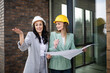 © Zoran Jesic - Female architects discussing blueprint at modern construction site