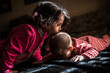 © Antonio Recena - ittle Girl Kissing Baby Sibling in Warm Sunlight at Home