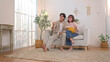 © Wosunan - Excited young couple cheering on sofa while watching television