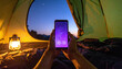 © SolaruS - Cozy night camping view from inside a tent, showing hands holding a glowing phone screen against a starry sky. Perfect for travel, technology, and outdoor lifestyle themes and advertising.